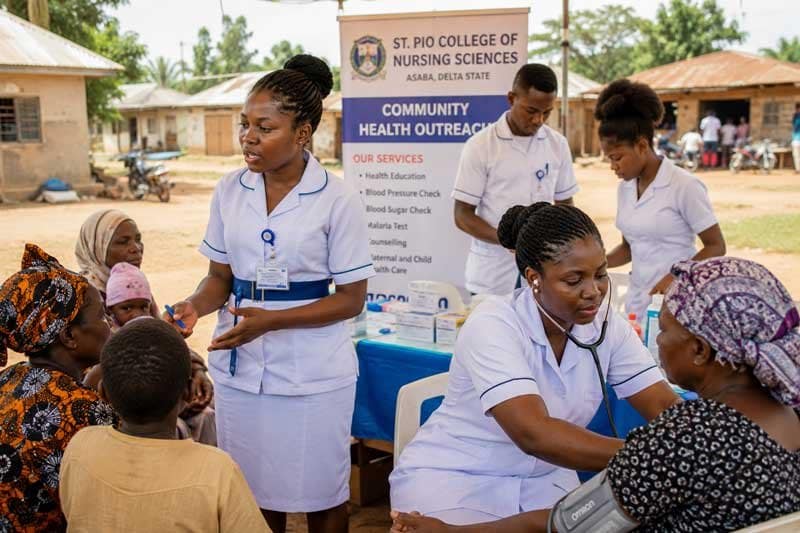 A group of African nurses conducting a healthcare outreach program in a rural Nigerian community